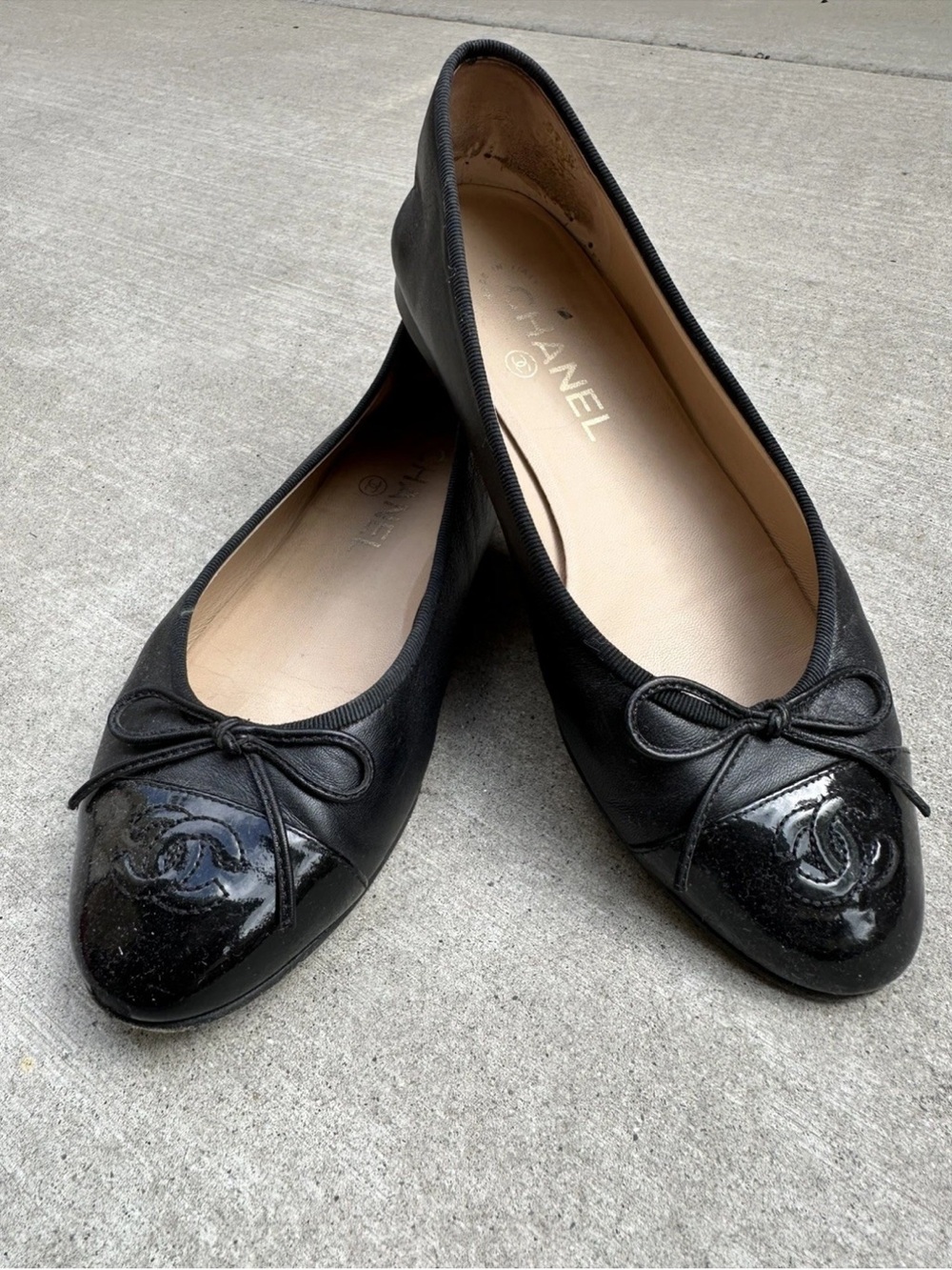 CHANEL Black Leather Ballet Flats with Patent Cap Toe and Bow